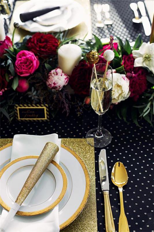 Juhli uudenvuodenaattoa kotona tyylikäs pöytäjärjestely musta valkoinen kulta tummanpunaiset kukat keskellä