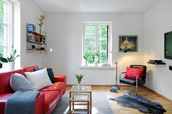 Skandinaavinen olohuone suunnittelee lumoavan vaikutelman punaisen sohvan