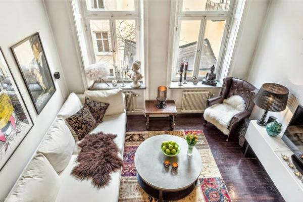 Skandinaavisia design -huonekaluja sohvapöydän maton ympärillä