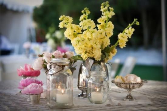 Kesäkukkien sisustusideoita valkoisia kynttilöitä pöydän koristeluun erityiselle illalliselle ulkona