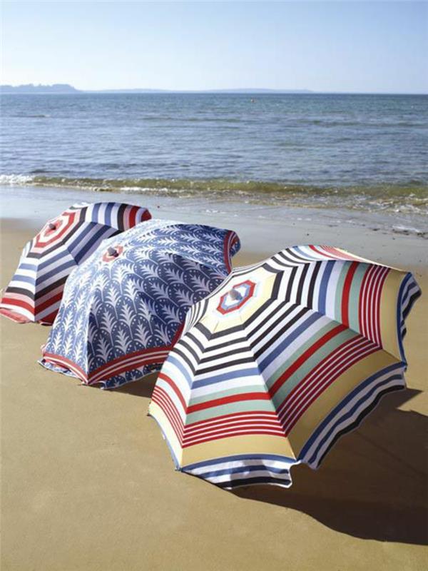 Aurinkovarjoja rannalla aurinkosuoja käyttää aurinkovarjo