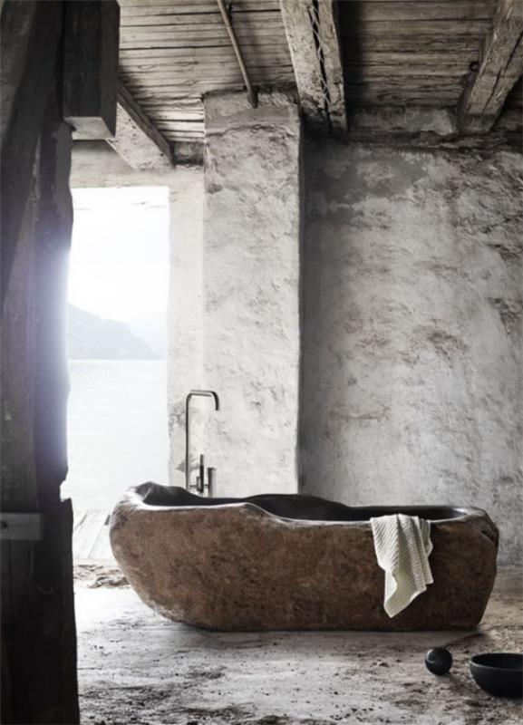 Kivi kylpyhuoneen kylpyammeessa kivestä orgaaninen muoto luonnollinen rakenne