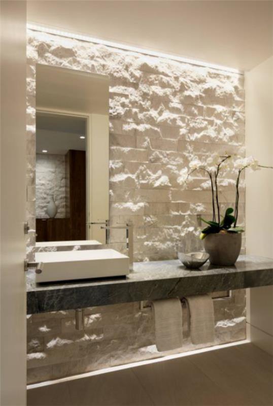 Kivi kylpyhuoneessa Kiviseinä valaistu oikein, kylpyhuoneen oikea valo tekee ihmeitä erittäin houkuttelevassa kuvassa