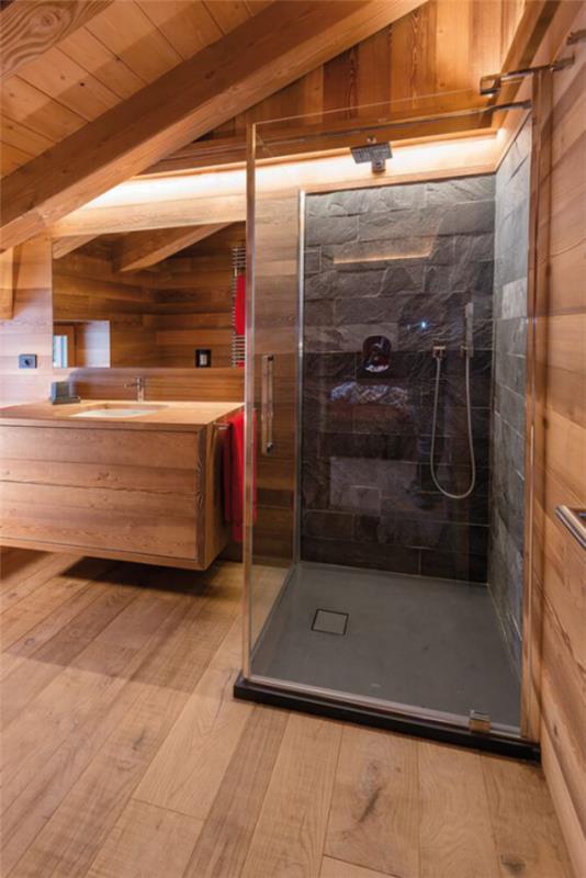 Kivi kylpyhuoneessa moderni kylpyhuone design kiviseinä tummanharmaassa lasisuihkussa paljon puuta