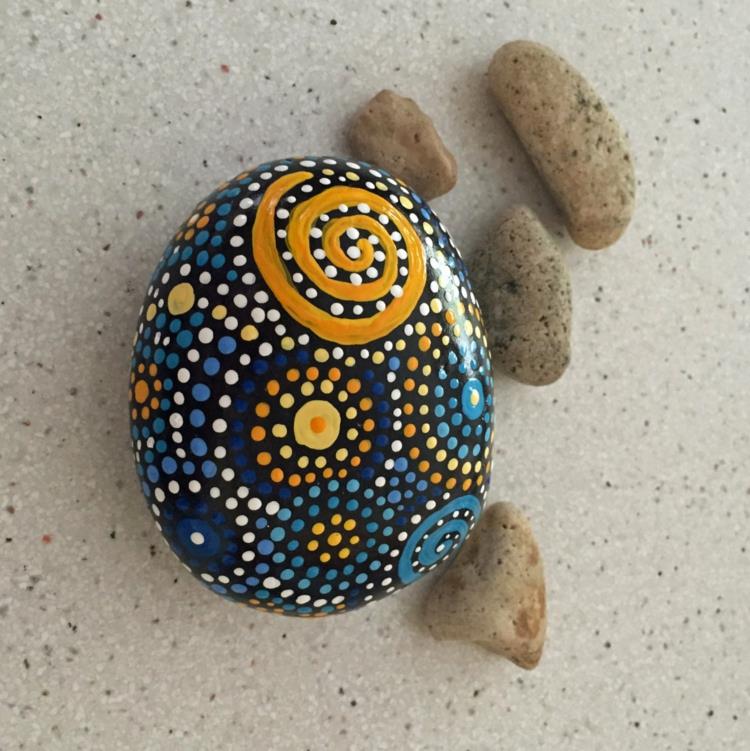 Kivet maalaavat pistekuvion sinisen keltaisen käsityön kivillä