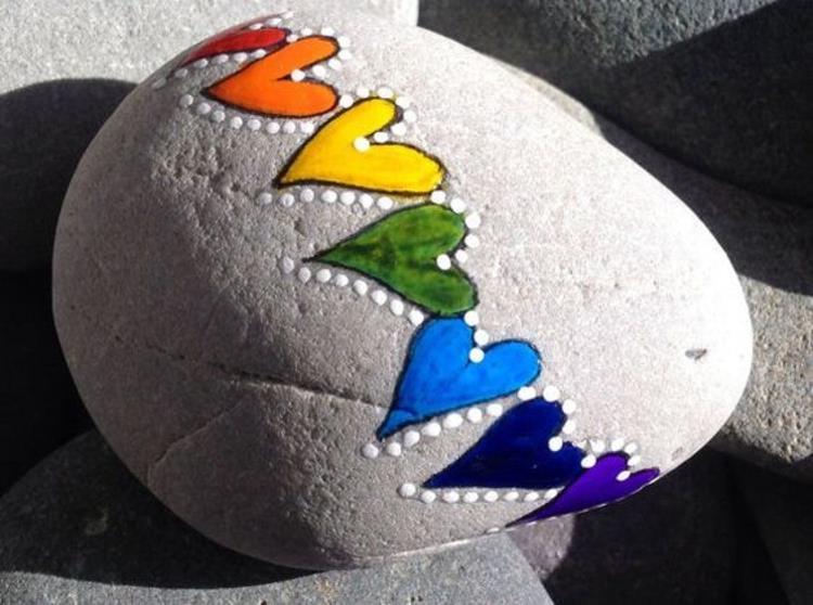 Kivet maalaavat värikkäitä sydämiä maalattuja kiviä
