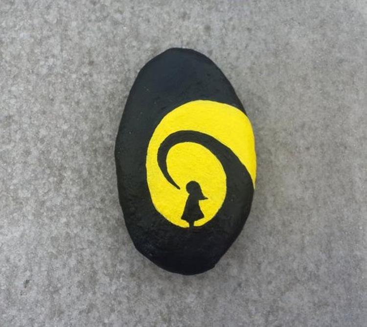 Maalaus kiviä musta keltainen tyttö tekee käsitöitä kivillä