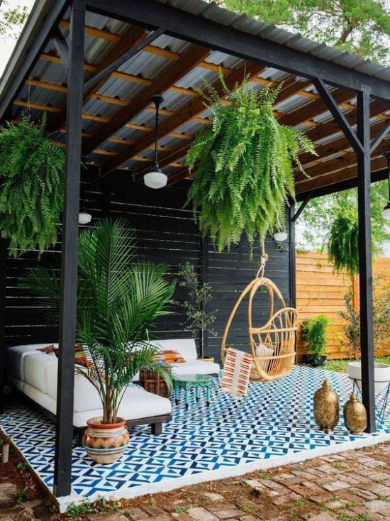 Patio on valmis kevääseen ja katettu patio -istuinalue korostuu monien vihreiden kasvien kanssa