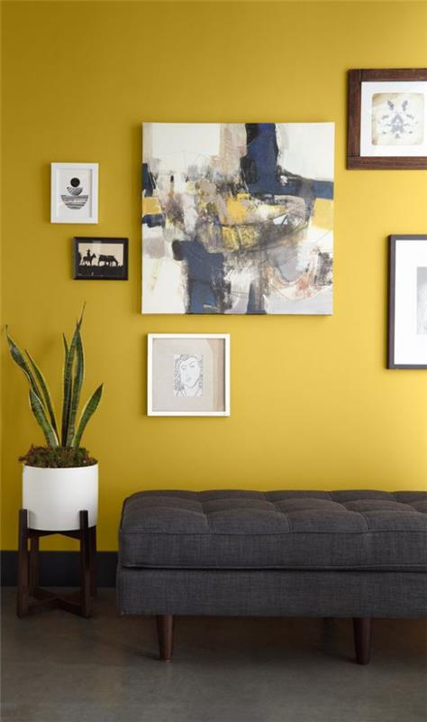 Trendivärit 2021 olohuoneen sisätiloissa harmaa lepotuoli keltainen aksentti seinämaalaus hyvä visuaalinen tasapaino