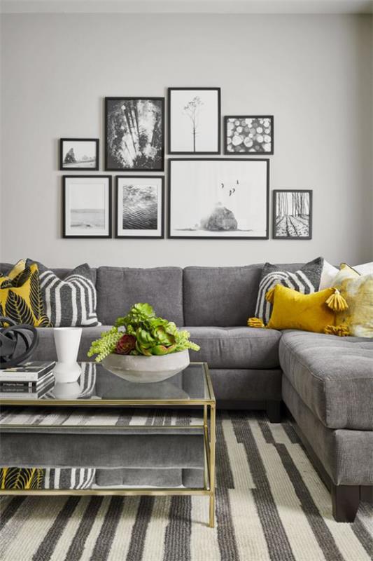 Trendivärit 2021 sisätiloissa, viihtyisä olohuone, seinämaalaukset, harmaa sohva, pienet keltaiset aksentit, virkistävät tunnelmaa