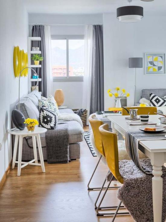Trendivärit 2021 modernin keittiö-olohuoneen sisustuksessa Harmaa hallitsee keltaisia ​​aksentteja hajallaan täällä ja siellä