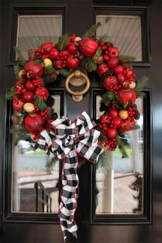 Oven seppele omenoilla tinker punaiset kypsät omenat ruusunmarjat paljon vihreää valko-musta ruudullinen keula kaunis oven koristelu.