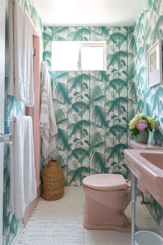 Trooppinen sisustus kylpyhuoneessa eksoottiset trooppiset lehdet tapetti paljon vihreitä pesualtaan wc -pyyhkeitä vaaleanpunaisessa hyvässä yhdistelmäkorissa valkoinen juoksija