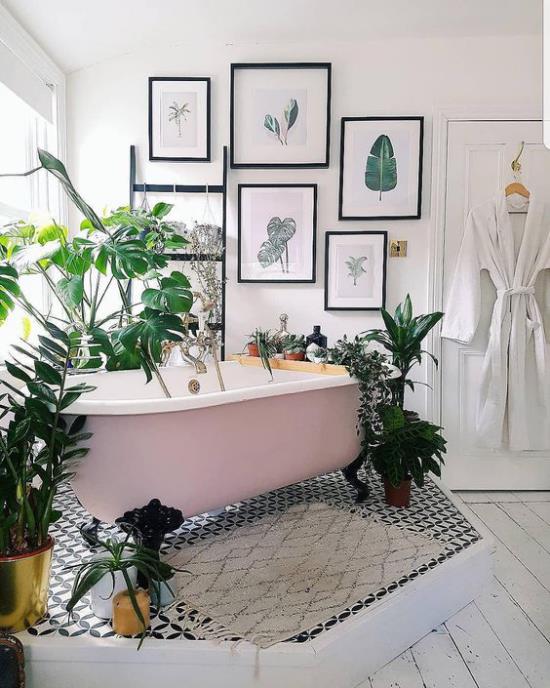 Trooppinen koristelu kylpyhuoneessa vapaasti seisova kylpyamme, jossa on kynsiä jalat terveisten ympäröimänä ruukkukasvit seinäkoristekuvat suuret eksoottiset lehdet