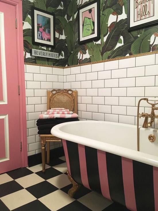 Trooppinen sisustus kylpyhuoneessa retro -tyylisessä vapaasti seisovassa kylpyammeessa vaaleanpunainen musta raidallinen vaaleanpunainen ovi seinäpaperipyyhkeet tuolilla