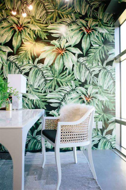 Trooppinen sisustus kotitoimistossa valkoiset huonekalut aksentti seinä suuret trooppiset lehdet tapetilla tyylikäs valaistus paljon luonnonvaloa