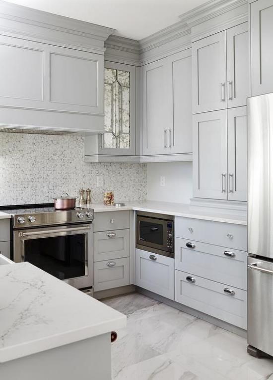 Maanalainen keittiö korkea harmaa seinäyksikkö paljon säilytystilaa Valkoiset marmoriset työtasot