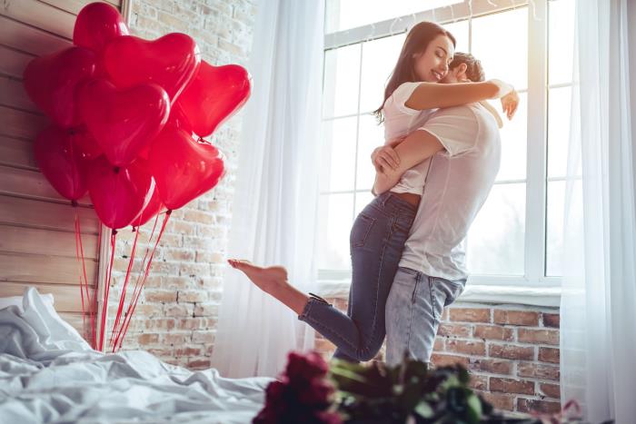 Rakastunut hänen horoskooppi ystävänpäivän punaiset ilmapallot punaiset ruusut onnellinen hänen nuori pari makuuhuoneessa