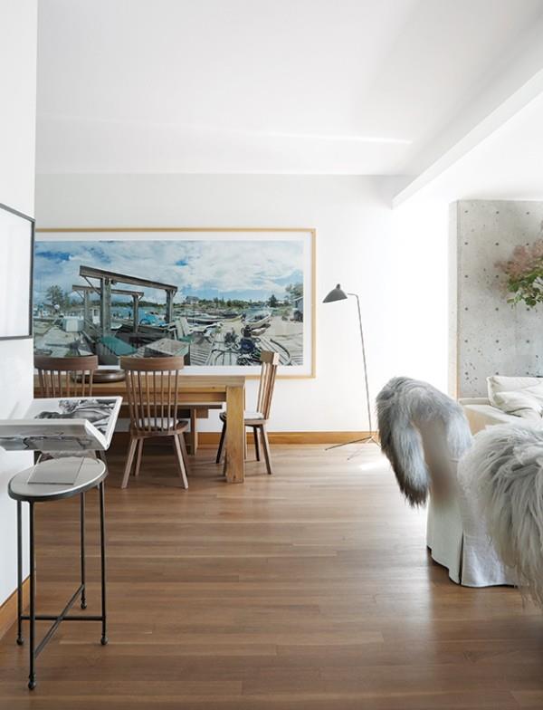 Valkoinen olohuone ja ruokasali, paljon puuta, suuri maalaus seinällä