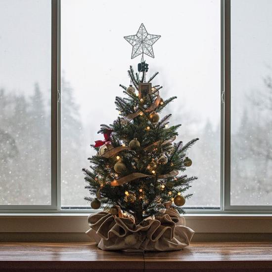Jouluikkunan koristelu pieni tyylikkäästi koristeltu joulukuusi kattilassa säkkikangassäkki tähti kultaa kimaltelevia palloja