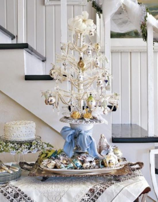 Joulukuusi koristellaan valkoisena ja hopeana pieni symbolinen joulukuusi kauniisti koristeltu ruokapöydälle