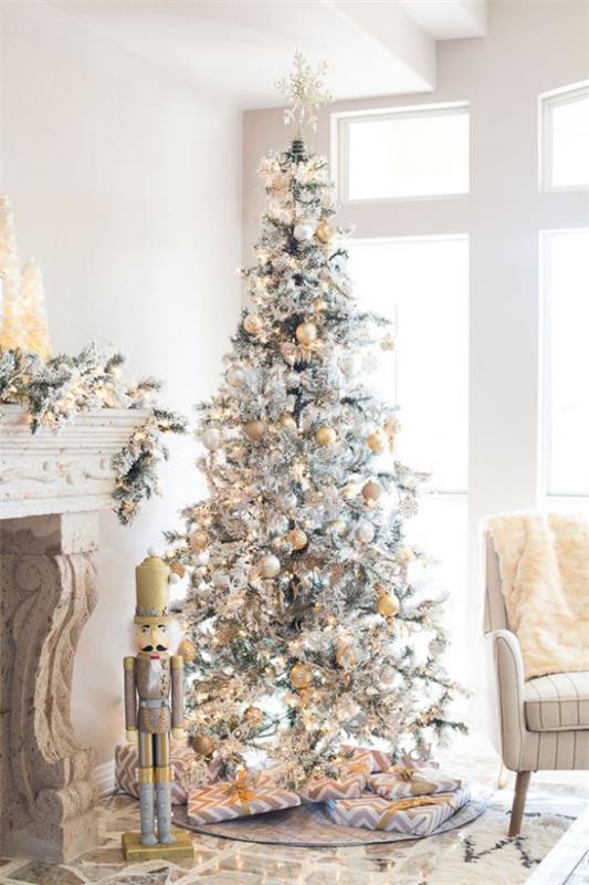 Joulukuusi koristele kauniisti koristeltu joulukuusi valkoisella ja hopealla käärityillä lahjoilla takan vieressä