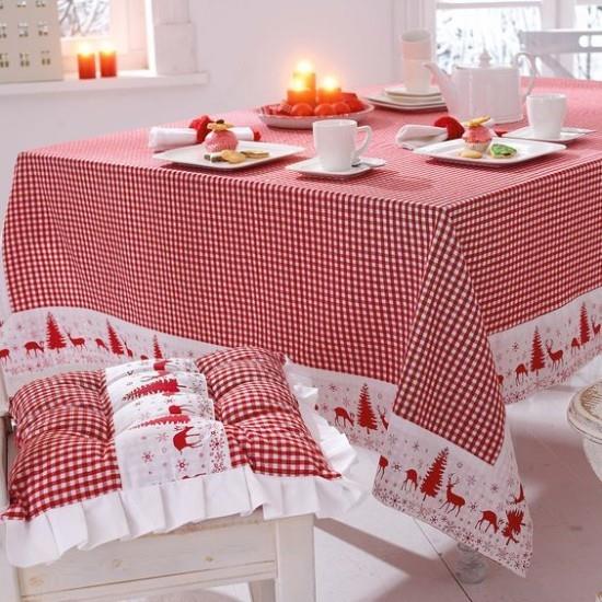Joulukoristeita punaisella ja valkoisella juhlapöydällä, kaunis ruudullinen viltti, istuintyyny