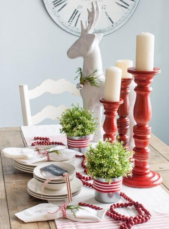 Joulukoristeiden ideoita punaisella ja valkoisella katetulla pöydällä valkoisia ruokia punainen kynttilänjalka