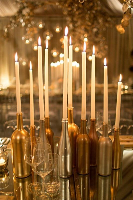 Joulukoristeita kultaisilla pulloilla ja kynttilöillä