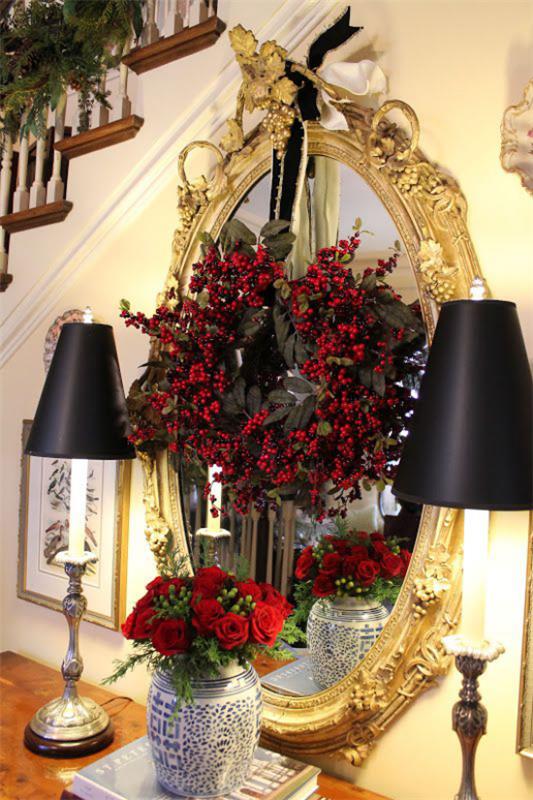 Joulukoristeet kultaa ja mustaa käytävällä korostavat kultaa ja mustia punaisia ​​ruusuja maljakossa peilin edessä