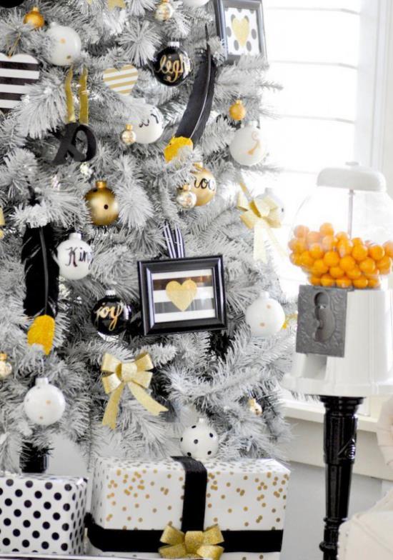 Joulukoristeet kultaa ja mustaa Valkoinen joulukuusi kääritty lahjoja, mukaan lukien yksittäiset aksentit kultaa ja mustaa