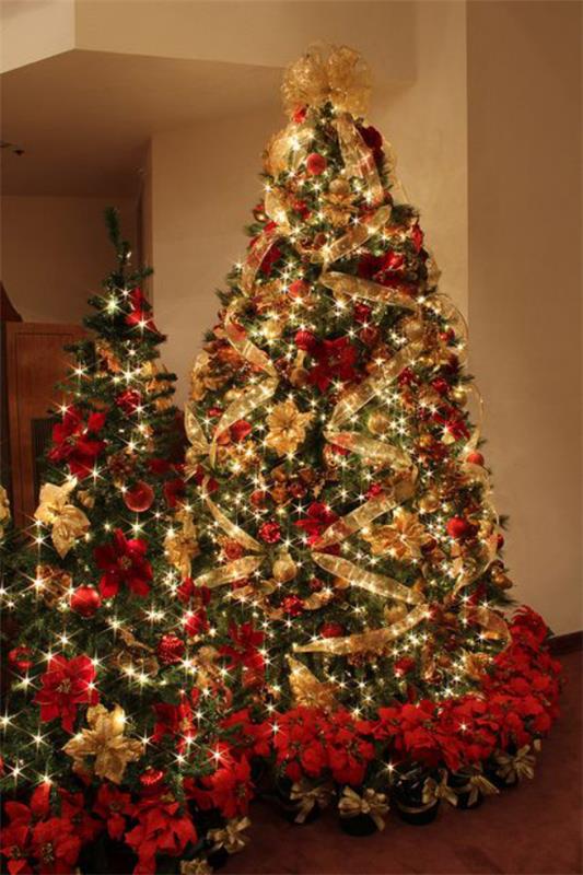 Joulukoristeet punaisella ja kullalla, kaksi joulukuusta vierekkäin lumoavasti koristeltu