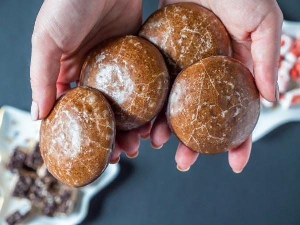 Ylhäältä katsottuna Naisen kädestä pidettävä joulu Saksalainen tumma suklaa Lebkuchen -kakku tumman taustan yli