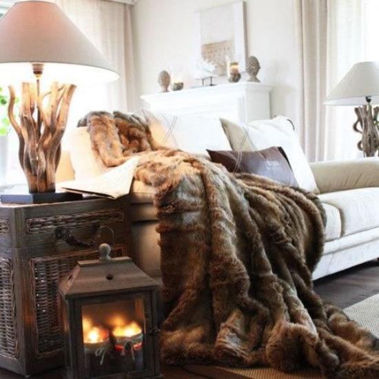 Talvikoristelu olohuoneessa kodikas tunnelma paljon lämpöä sisältävä sohva kevyellä verhoilulla suklaa ruskea lämmin peittolyhty kynttilälampuilla