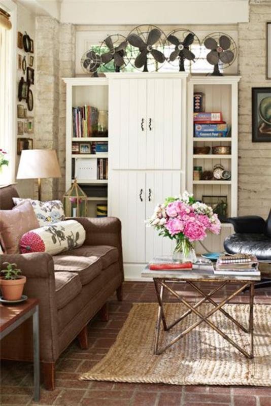 Kodin tarvikkeet modernissa olohuoneessa retro koskettaa kauniita vaaleanpunaisia ​​kukkia kiviseinä