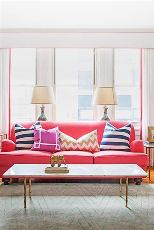 Kodin tarvikkeet modernissa olohuoneessa vaaleanpunainen sohva värikkäät koristetyynyt lamput patsas pronssi
