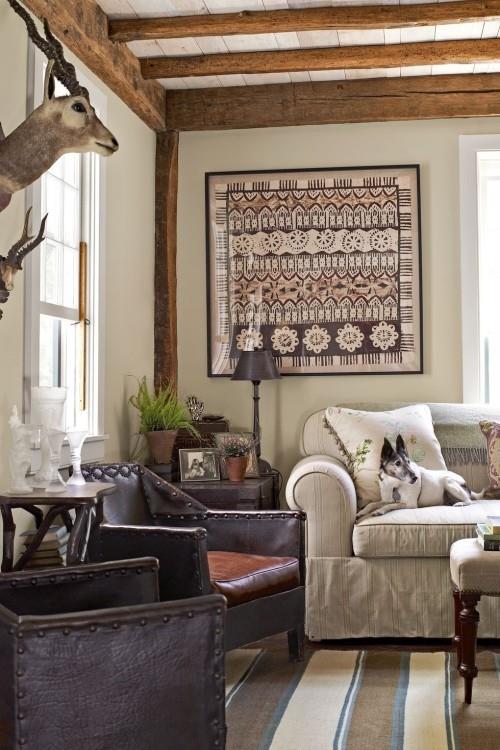 Olohuone maalaistyylisessä maalaismaisessa seinäkoristeessa peuran pään nahkainen nojatuoli raidallinen matto