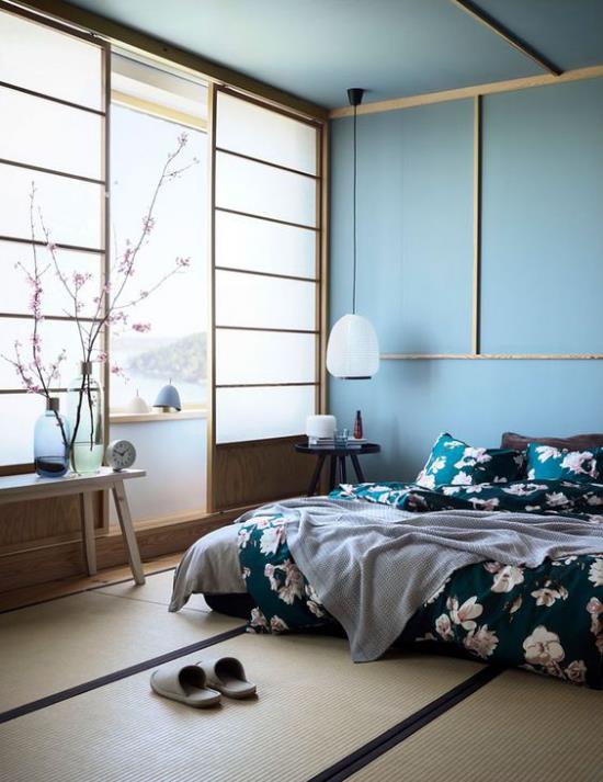 Zen makuuhuoneen sininen sisustus paljon päivänvaloa kukkivat kirsikka oksat huoneen koristeet