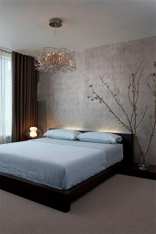 Zen -makuuhuone kaunis huonesuunnittelu, vaaleansininen lakanat hienovarainen valo sängyn vieressä olevan lampun takana kukkivat oksat