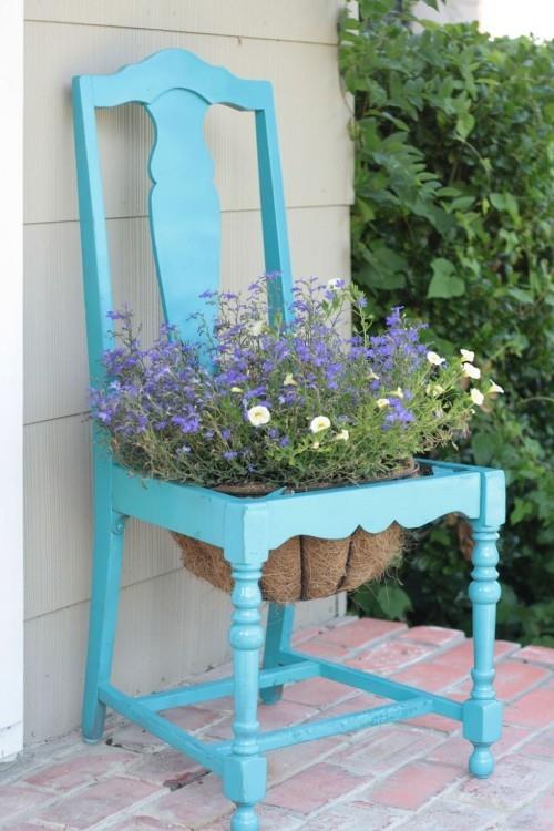 vanha tuoli sinisellä maalatulla kukkaruukulla puutarhan sisustuksen keskellä
