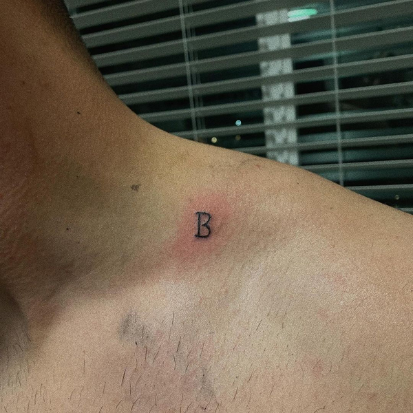 B betűs tetoválás a nyak közelében