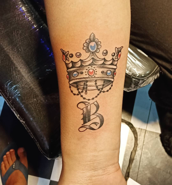 Királyi B betűs tetoválás a karon