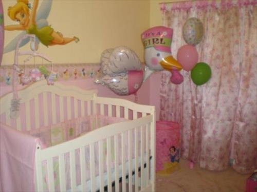 Vauvan huoneen sängyssä keltaisia ​​ja vaaleanpunaisia ​​sisustuselementtejä