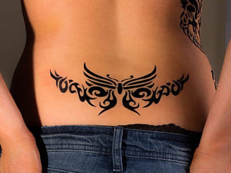 Nagy felbontású kép egy lányról, akinek alsó hátsó törzsi tetoválása van