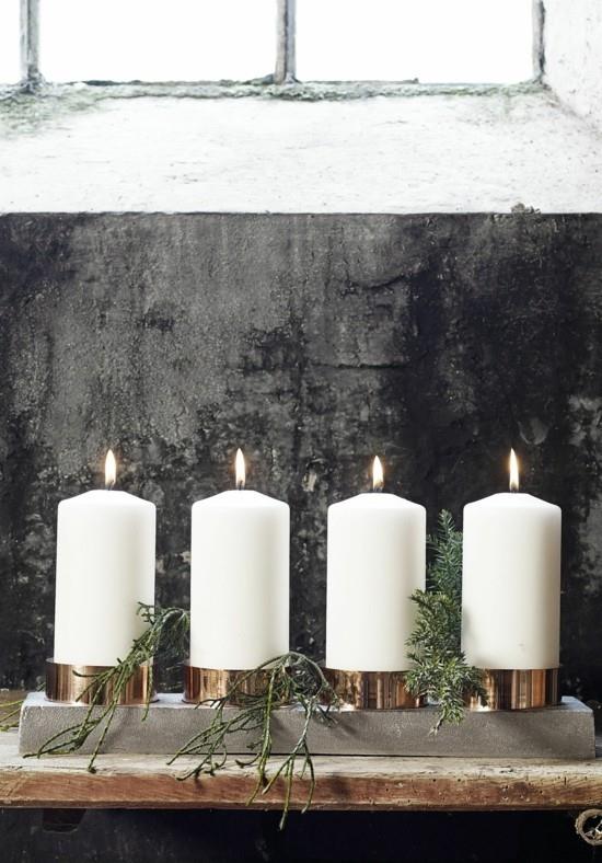 betoninen adventtiseppele koristele valkoisia pylväskynttilöitä
