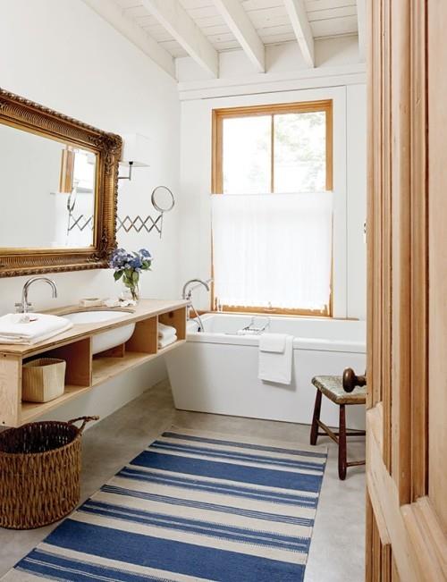 sininen ja valkoinen raidallinen matto piristävät pientä kylpyhuonetta ja tuovat tuulta