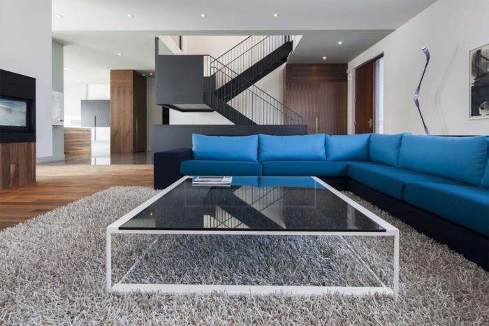 sininen sohva kulmasohva lasi sohvapöytä beige matto