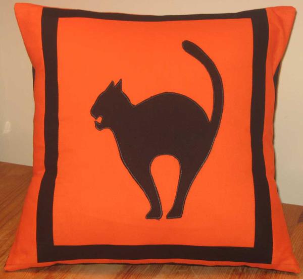 viileitä eläviä ideoita Halloween -koristeluun kissatyyny oranssi musta
