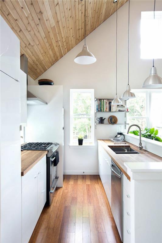 kalteva katto perustettu pieni keittiö valkoiset huonekalut riippuvalaisimet