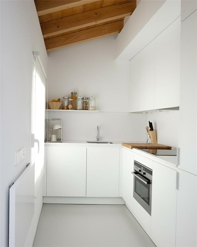 Kalteva katto asetti valkoisen keittiön minimalistiseksi